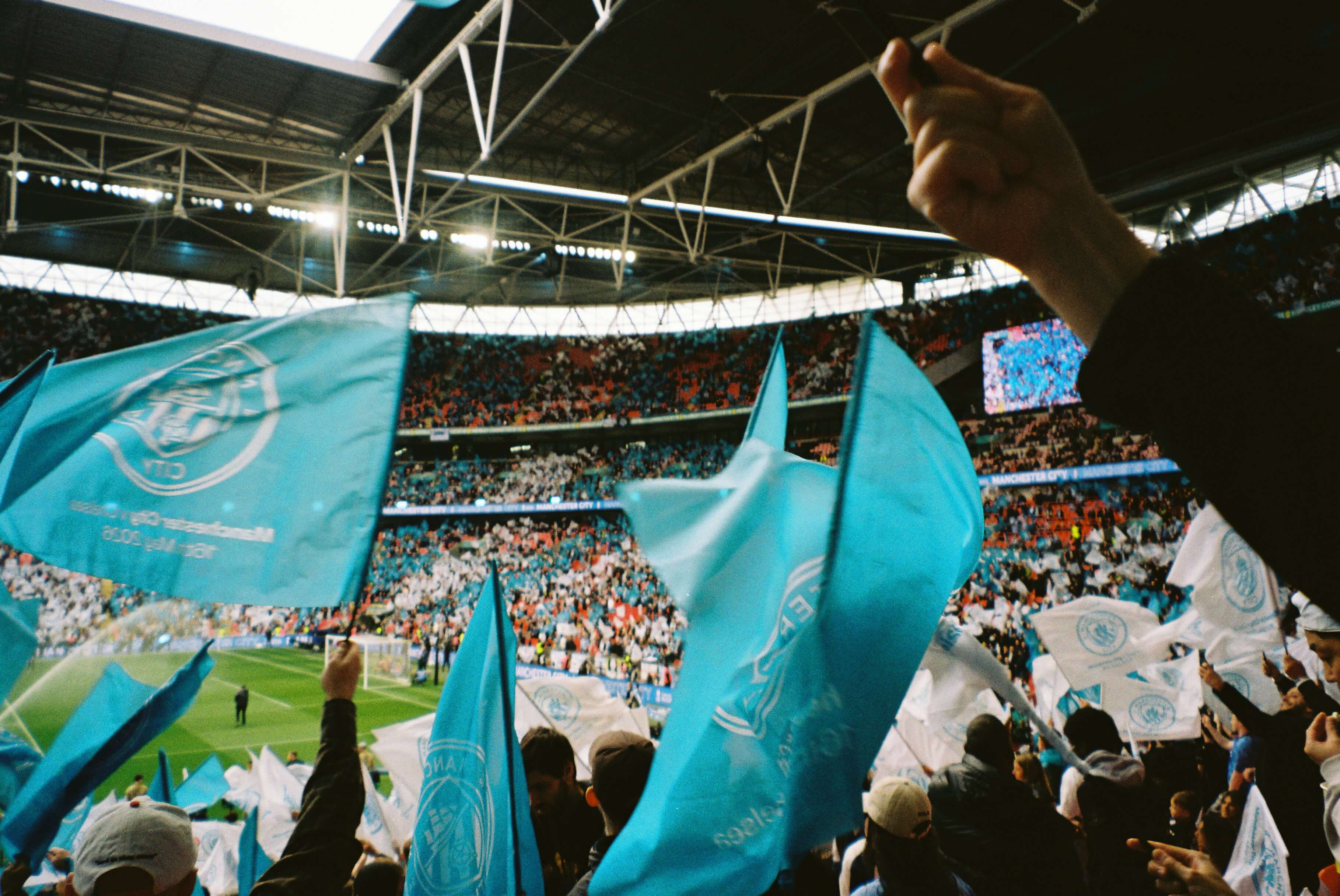 Fans waving team-colored flags in a packed stadium